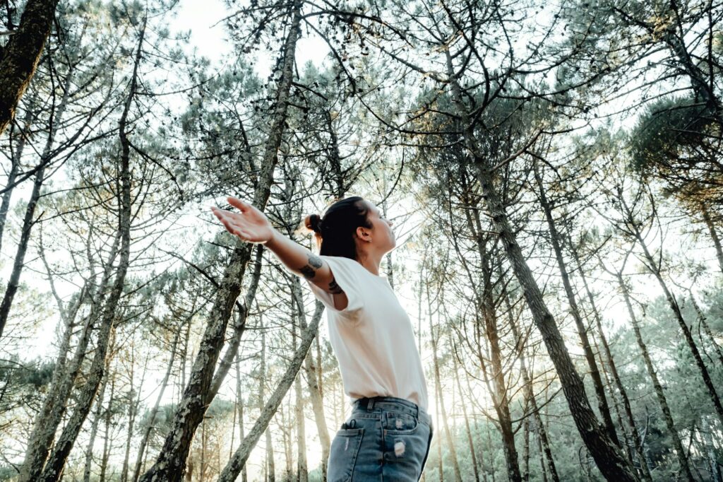 young woman breathing clean air in nature forest.Fresh outdoor, wellness healthy lifestyle concept